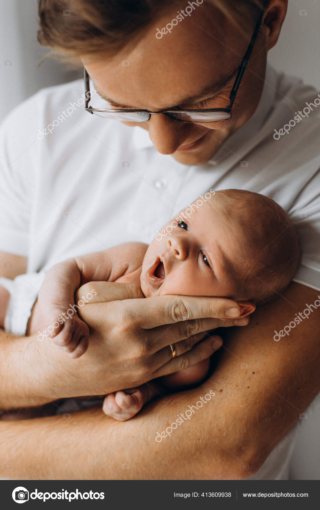 Hombre guapo sostiene adorable bebé recién nacido niña en brazos