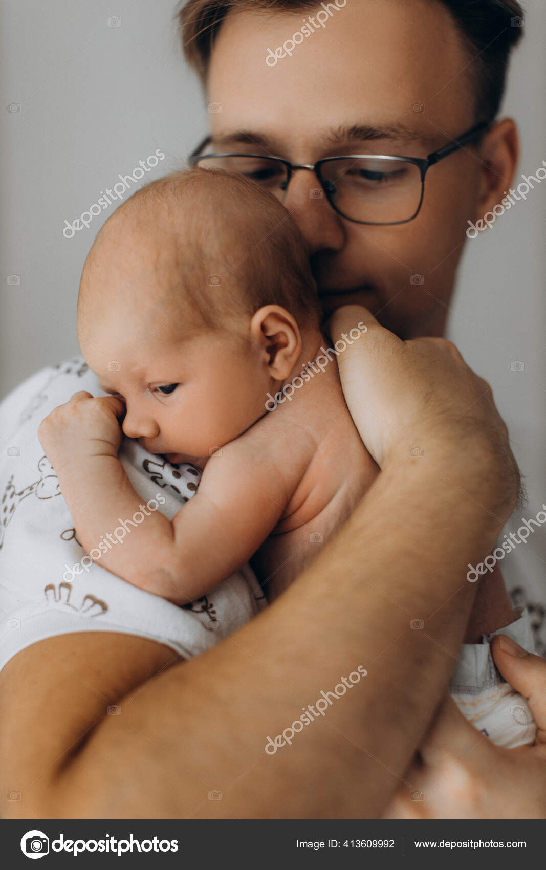 Hombre guapo sostiene adorable bebé recién nacido niña en brazos