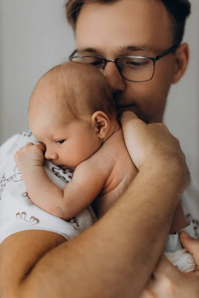 Pria tampan memegang bayi perempuan yang baru lahir menggemaskan dalam pelukan, merawat ayah terlihat dengan cinta pada putri kecil, menikmati momen-momen pengasuhan yang lembut, konsep kebapakan — Stok Foto