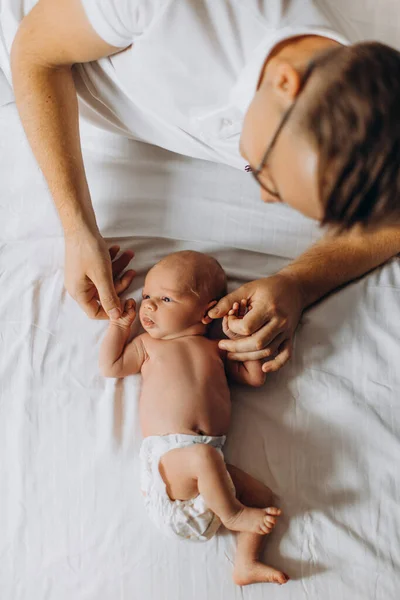 Padre amoroso con adorable niña recién nacida, padre cariñoso sostiene pequeños brazos de hija pequeña, disfruta de tiernos momentos de crianza, sonriente, concepto de paternidad — Foto de Stock