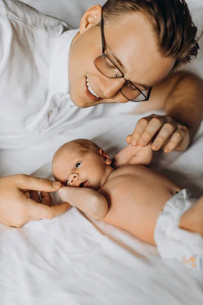 Padre amoroso con adorable niña recién nacida, padre cariñoso sostiene pequeños brazos de hija pequeña, disfruta de tiernos momentos de crianza, sonriente, concepto de paternidad — Foto de Stock