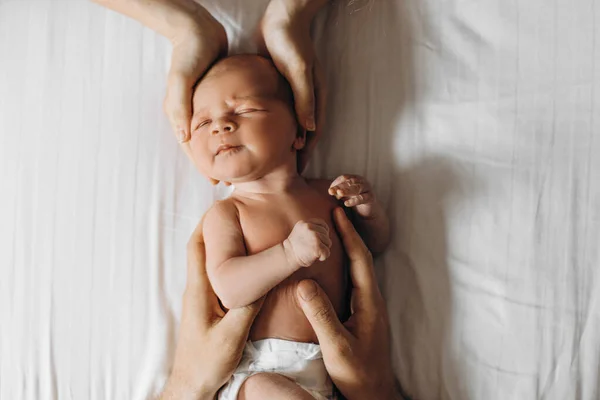 Bella neonata sdraiata sul letto in braccio ai genitori premurosi, mamma amorevole e papà premuroso toccano delicatamente adorabile bambina, momenti felici in famiglia, concetto di genitorialità — Foto Stock