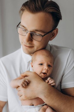 Şefkatli baba, tapılası yeni doğmuş bebeği nazikçe kucağına alır, mutlu baba, küçük kızıyla geçirdiği anların tadını çıkarır, gülümser, ebeveynlik ve babalık kavramı.