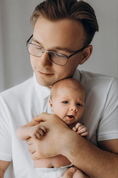 Zorgzame vader zachtjes te houden schattige pasgeboren baby meisje in de armen, gelukkig vader genieten van momenten met kleine dochter, glimlachen, ouderschap en vaderschap concept — Stockfoto
