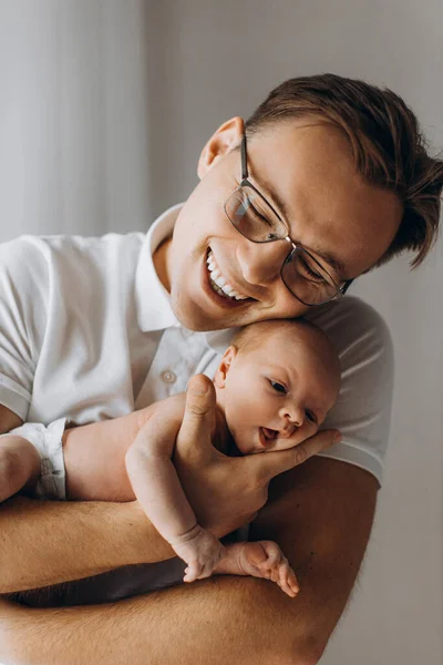 Ayah yang peduli dengan bayi perempuan yang baru lahir yang menggemaskan, ayah yang tampan memeluk putri kecil yang cantik, menikmati saat-saat orangtua yang bahagia, konsep tersenyum, menjadi ayah yang baik — Stok Foto