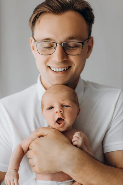 Retrato de hombre guapo con adorable niña recién nacida, padre cariñoso sujeta suavemente a la pequeña hija en brazos, disfruta de momentos de paternidad tierna, sonriente, concepto de paternidad — Foto de Stock