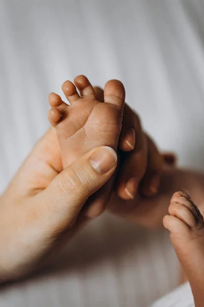Retrato de hermosa pierna pequeña con dedos pequeños, de adorable niña recién nacida, en brazos parentales cariñosos, momentos familiares felices, concepto de nacimiento e infancia — Foto de Stock