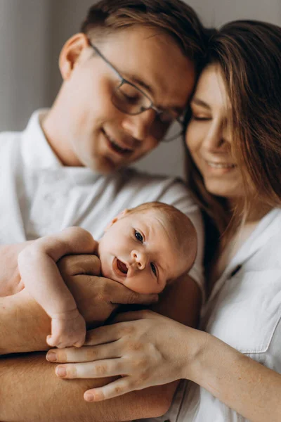 Genitori premurosi con il neonato, amorevole papà tenere delicatamente la piccola figlia in braccio, bella madre tenere minuscola mano della bambina, sorridente, godersi momenti felici, giovane concetto di famiglia — Foto Stock