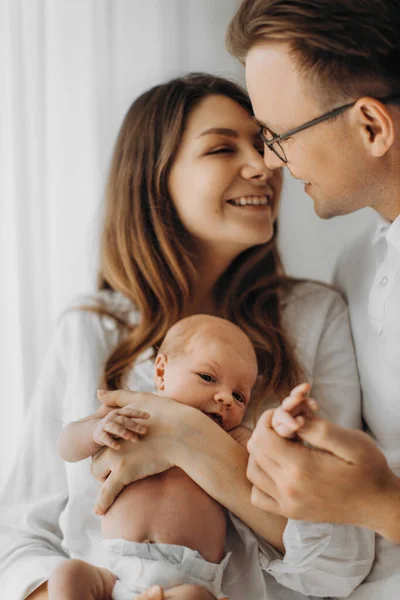 Pais felizes com bebê recém-nascido, mãe carinhosa segurar pequena filha nos braços, belo pai gentilmente segurar a mão da menina, sorrindo, desfrutar de momentos felizes, conceito de família jovem — Fotografia de Stock