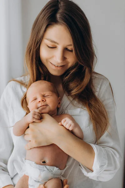Bella donna tenere bella neonata in braccio, mamma felice godere di momenti teneri con la piccola figlia, sorridente, concetto di maternità e genitorialità — Foto Stock