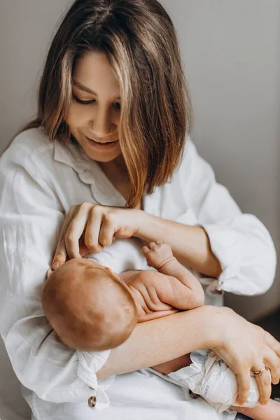 Mujer bonita sostener hermosa niña recién nacida en brazos, mamá feliz disfrutar de momentos tiernos con hija pequeña, sonriente, maternidad y el concepto de crianza — Foto de Stock