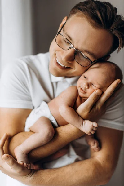 Zorgzame vader met mooie pasgeboren baby meisje, liefhebbende vader in de armen mooie kleine dochter, genieten van tedere ouderschapsmomenten, glimlachen, vaderschap en kindertijd concept — Stockfoto