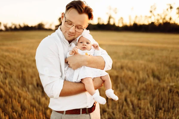 Красивый отец с очаровательной маленькой дочерью на поле, заботливый папа держать милый новорожденный девочка в руках, нежные семейные моменты, воспитания и отцовства концепции — стоковое фото
