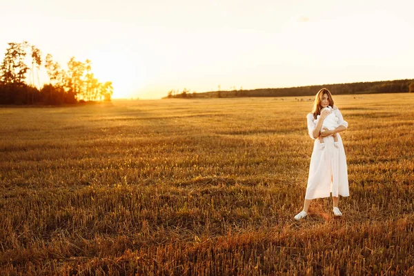Mulher elegante com linda menina recém-nascida andando no campo, linda mãe segurar nos braços fofa filhinha, desfrutar de momentos familiares felizes, parentalidade e conceito de maternidade — Fotografia de Stock