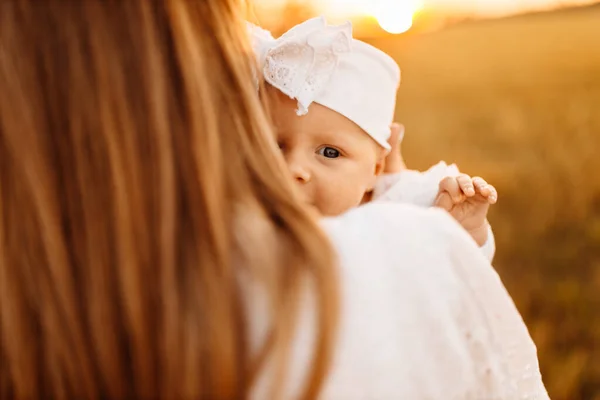 Ritratto di bella neonata con bella madre che cammina sul campo, elegante donna stretta in braccio piccola figlia, momenti felici in famiglia, concetto di genitorialità e maternità — Foto Stock