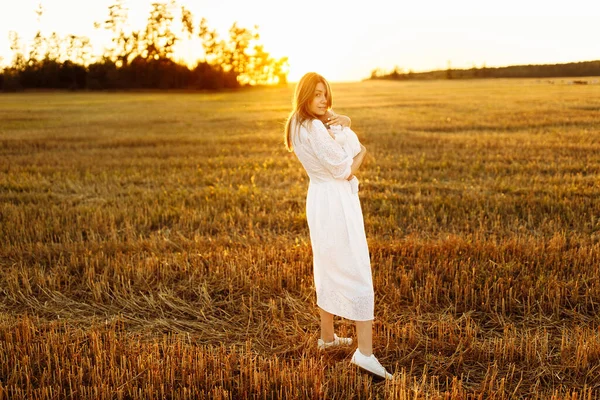 Mulher elegante com linda menina recém-nascida andando no campo, linda mãe segurar nos braços fofa filhinha, desfrutar de momentos familiares felizes, parentalidade e conceito de maternidade — Fotografia de Stock