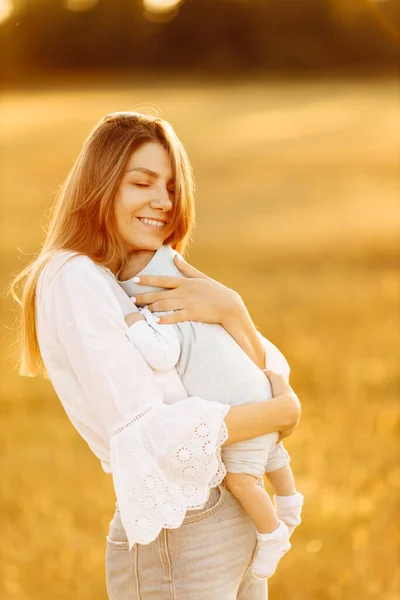 Mulher adorável com linda menina recém-nascida no campo, mãe feliz segurar filhinha bonito nos braços, sorrindo, desfrutar de cada momento de parentalidade, conceito de maternidade — Fotografia de Stock