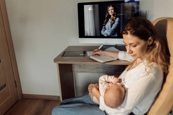 Üzleti nő ül a székben, fiatal anya tartsa a karját kislánya, szép hölgy szünetet a baba lány, élvezze a boldog pillanatokat, dolgozik az otthoni online koncepció — Stock Fotó