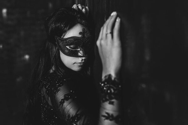 portrait of sensual elegant woman in black mask with long curly hair.