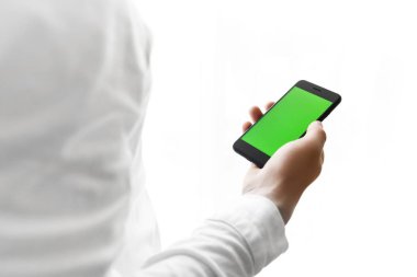 Pencere üzerinde beyaz izole yakınındaki Smartphone yakışıklı genç adam kullanır 