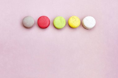 Renkli bir grup Fransız tatlı macaroons veya macarons izole metin, en iyi görünüm için yer ile limonata renk arka plan üzerinde