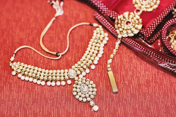 Glitter necklet with pearl of indian bride on red background