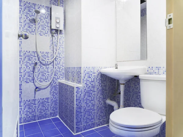 Küçük mavi seramik renk, eski stil tuvalet ile beyaz tuvalet, lavabo ve ayna dekorasyon ile temiz tuvalet.