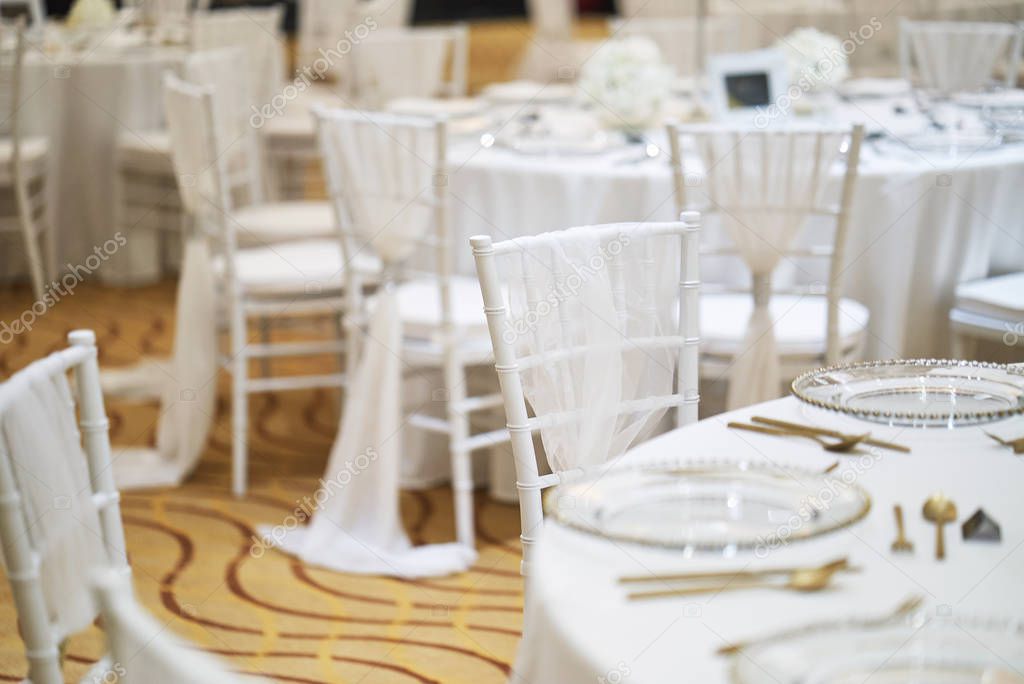 Wedding reception dinner table setting indoor with white chiavari chairs for luxury wedding party