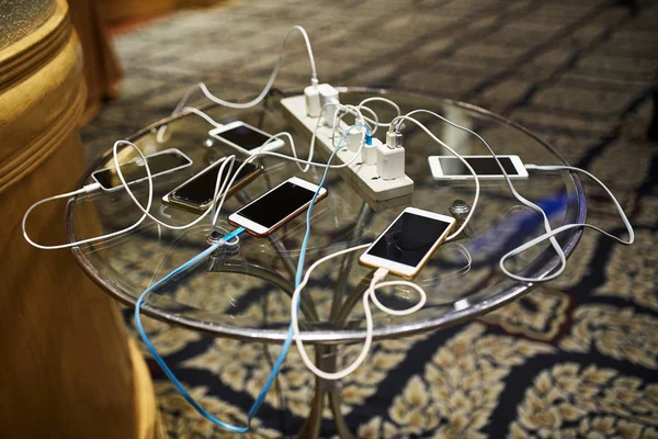 Group Smartphones Charging Glass Table Sharing Same Plug — Stock Photo, Image