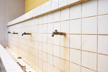 Seramik duvar, eski okul su kırsal okulun genel alanda kırık musluk su musluk monte