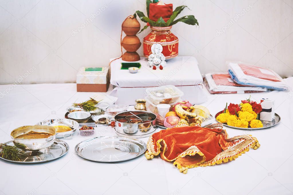 The Ganesha statue (Hindu god of wisdom) with red velvet of kalash on the back and worship items for thread ceremony (puja, pooja) of indian wedding event
