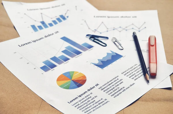 Financial dummy statistics document report with pie graph, bar chart, line graph on the table with pencil and highlight pen. Financial revenue, Market analysis, earnings, loan and credit concept.