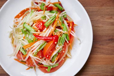 Geleneksel madde ot sosu ve kırmızı biber, domates, uzun fasulye ile karışık Tay gıda papaya salatası veya Somtam. Yakın çekim.