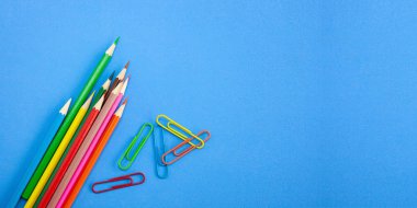 Okula geri kavramları banner şablon tasarımı, renkli mum boya kalemleri ve klip sanat ve canlı mavi arka plan ile kopya alanı üzerinde çizim. Yukarıdan görünüm, portre.