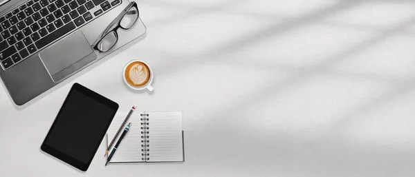 白色的办公桌工作场所与咖啡的概念与复制空间。笔记本电脑和平板电脑. — 图库照片#