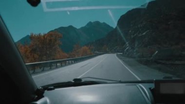 Arabada ön pencereden görünüm, Araba boş dağ yolu üzerinde sürüş, yavaş hareket. Rusya 'da yaz gezisi. Dağlar, nehir, yol ve ağaçlar üzerinde araba görünümü. Yavaş hareket.