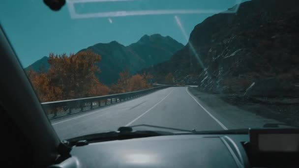 Θέα από το μπροστινό παράθυρο στο αυτοκίνητο, το αυτοκίνητο οδηγεί σε άδειο ορεινό δρόμο, αργή κίνηση. Οδικό ταξίδι το καλοκαίρι στη Ρωσία. Θέα από το αυτοκίνητο στα βουνά, το ποτάμι, το δρόμο και τα δέντρα. Αργή κίνηση. — Αρχείο Βίντεο
