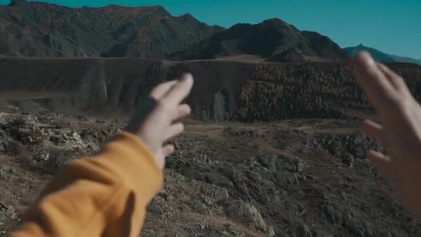 La fille regarde le soleil à travers sa main. Vue sur la nature depuis la première personne. Une jeune fille regarde ses mains, ses montagnes et sa rivière en arrière-plan. Mouvement lent . — Video