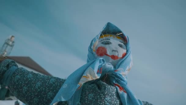 Títere de paja contra el cielo azul. La muñeca será quemada en el carnaval. La cámara se mueve alrededor de los trapos en cámara lenta . — Vídeo de stock