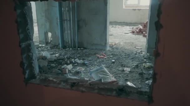 Ruines et débris de la vieille maison en brique. La caméra se déplace à travers la fenêtre vers la poubelle de pierres. Briques et ciment se trouvent dans un appartement inachevé . — Video
