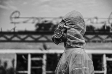 The scientist put on a respirator and a white protective suit against radiation. Close-up profile of a girl who cares about ecology. clipart