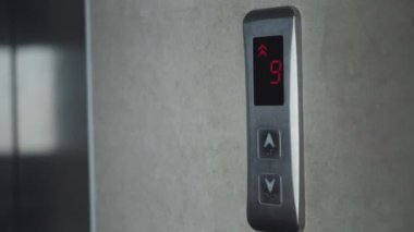 Genç Kadın Yukarı çıkmak için Asansör Düğmesine BasAr. Metal asansör. Parmak, ok işaretli olarak düğmeye basar.