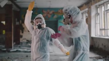 Bilim adamları solunum cihazını takıp rap klibi için dans ediyorlar. Radyasyon yüzünden koruyucu giysili kızlar müziğe yöneldi. Çevresel tema. Novosibirsk 'te terk edilmiş korkunç bir bölge. Coronavirus salgınında, COVID-19.