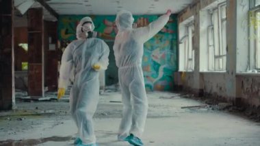 Bilim adamları solunum cihazını takıp rap klibi için dans ediyorlar. Radyasyon yüzünden koruyucu giysili kızlar müziğe yöneldi. Çevresel tema. Novosibirsk 'te terk edilmiş korkunç bir bölge. Coronavirus salgınında, COVID-19.