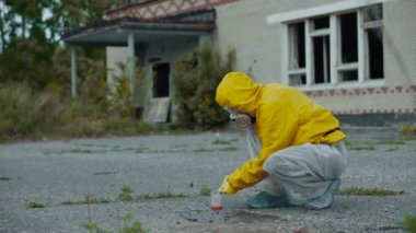 Terk edilmiş bir bölgedeki bir bilim adamı kanıt toplar. Coronavirus salgını, COVID-19. Radyasyon ve zararlı kirliliklere karşı koruyucu giysi. Solunum cihazındaki kız ekolojiyle ilgileniyor.. 