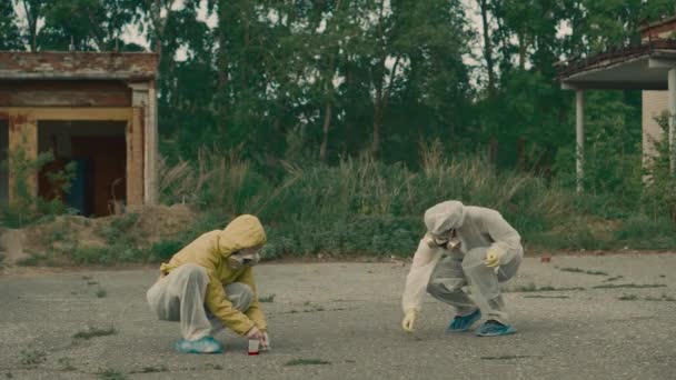 Dos personas en respiración trabajando en una zona abandonada. Coronavirus en pandemia, COVID-19. Recopilar pruebas en Chernóbil, Pripyat. Mujeres con trajes de protección blanca comprueban la ecología. Espacio interior radiactivo. Video de 4k. — Vídeos de Stock