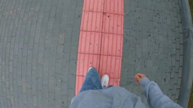 Birinci şahıs videosu. Genç bir adam kör için bir rahatlama ile pembe bir şerit boyunca hareket eder. Görme yetisini kaybetmiş insanlar için yol. Park Rusya'da engelliler için donatılmış.