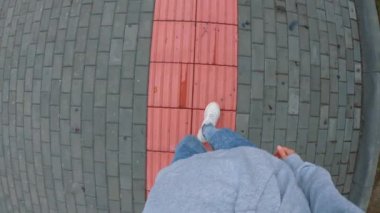 Birinci şahıs videosu. Genç bir adam kör için bir rahatlama ile pembe bir şerit boyunca hareket eder. Görme yetisini kaybetmiş insanlar için yol. Park Rusya'da engelliler için donatılmış.