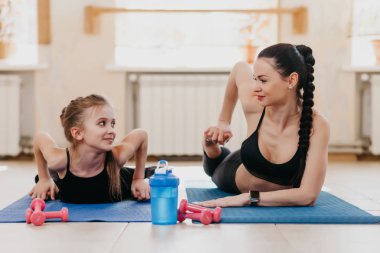 Anne ve kızı spor salonunda esneme yapıyor