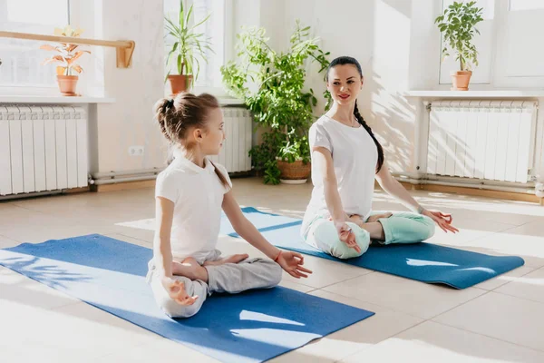 mom and daughter do yoga